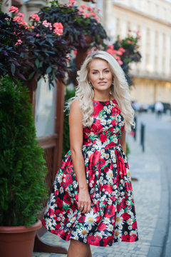 Portrait of a beautiful blonde in dress in flowers