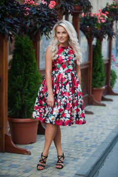 Portrait of a beautiful blonde in dress in flowers
