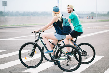 Obraz premium Rear view of a happy couple walking holding bike