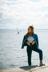 young beautiful woman in jeans clothes outdoors. portrait of a girl with freckles on her face, stylish girl on sea beach, on a sunny summer autumn day.