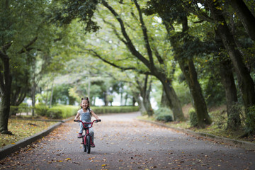 Happy little girl riding a bicycle