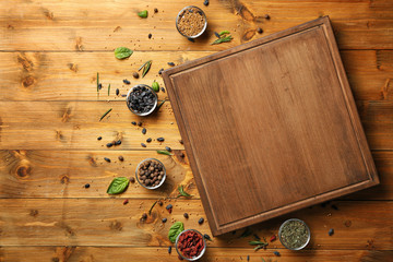 Composition with wooden board, spices and herbs on table