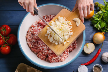 Woman preparing delicious turkey meatloaf in bowl