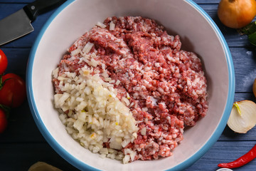 Bowl with ground turkey and ingredients for delicious meatloaf on wooden table