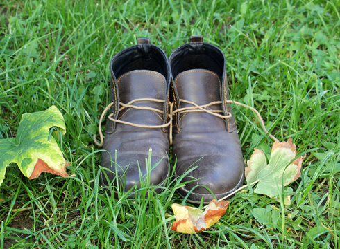Warm men's leather boots on a grass background
