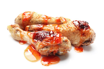 Roasted chicken legs in tomato sauce on white background