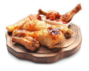 Roasted chicken legs in sauce on white background