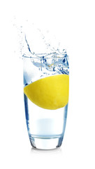Fototapeta na wymiar Falling sliced lemon into glass with water on white background