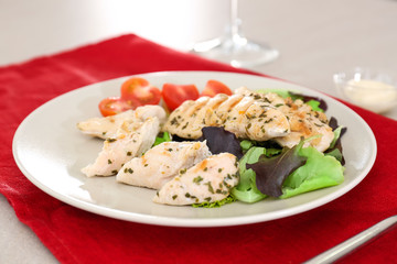 Plate with tasty chicken meat and tomatoes on table. Cooking for one concept