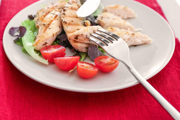 Plate with tasty chicken meat and tomatoes on table. Cooking for one concept