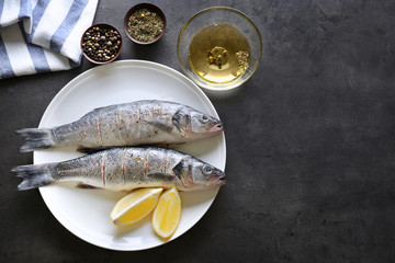 Fresh fish with slices of lemon on plate