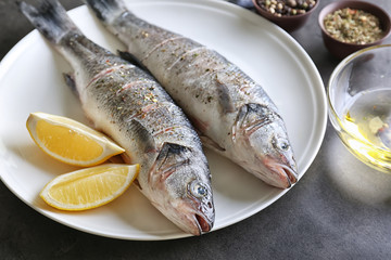 Fresh fish with slices of lemon on plate