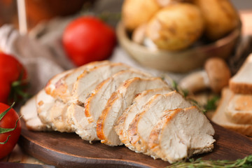 Delicious sliced turkey breast on wooden board
