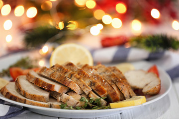 Plate with delicious sliced turkey breast against blurred lights
