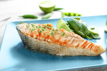 Plate with slice of delicious salmon on table, closeup