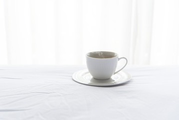 Fresh morning coffee on the white bed in the sunny day.  Lifestyle Concept
