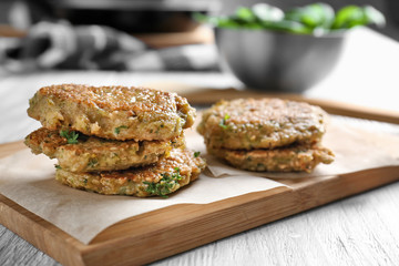 Delicious broccoli pancakes on wooden board in kitchen
