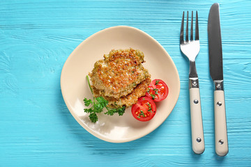 Delicious broccoli pancakes with cherry tomato and fresh parsley on blue wooden background