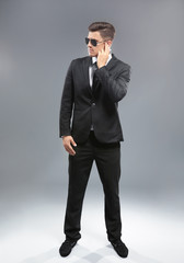 Handsome security guard on grey background