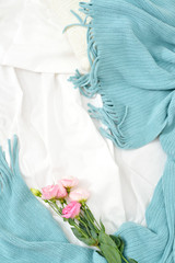 Flat lay pink flowers on white blanket with turquoise plaid