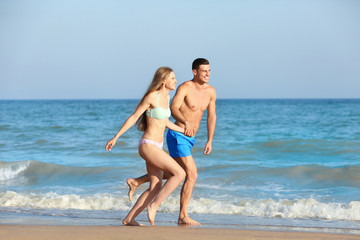 Fototapeta na wymiar Happy young couple on sea beach