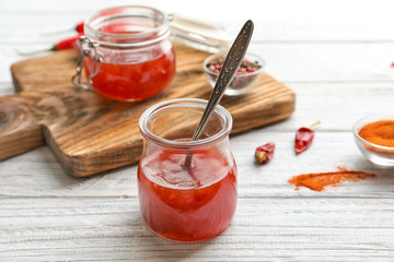 Composition with chili sauce in jars on table