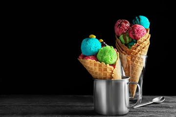 Ice cream with candies and chocolate syrup on black background