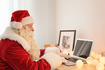 Authentic Santa Claus using laptop at table