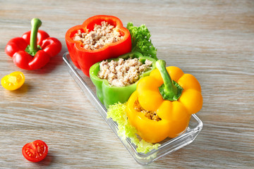 Quinoa stuffed peppers in baking dish on wooden background