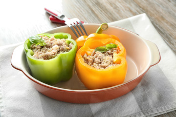 Quinoa stuffed peppers in casserole dish on dinner table
