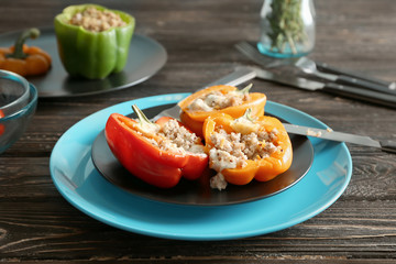 Plate with quinoa stuffed peppers on table