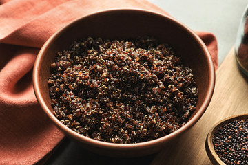 Bowl with boiled quinoa grains on kitchen table