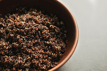 Bowl with boiled quinoa grains on kitchen table