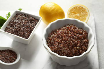Bowls with boiled and raw quinoa grains on kitchen table