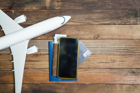 model airplane and smartphone on a wooden background