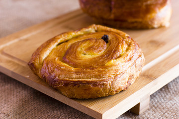 Twisted bun with raisins from puff pastry on sackcloth