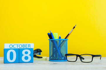 October 8th. Day 8 of month, wooden color calendar on teacher or student table, yellow background . Autumn time. Empty space for text