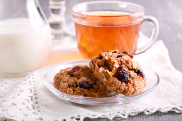 Oat cookies with cranberry, dried apricot and nuts on saucer