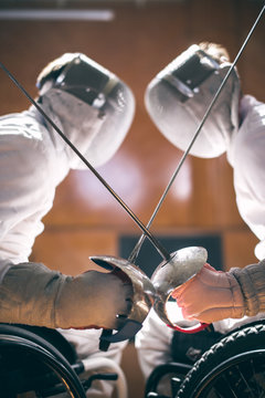 Two male disabled fencing athletes fight. men wear unbranded sports clothes