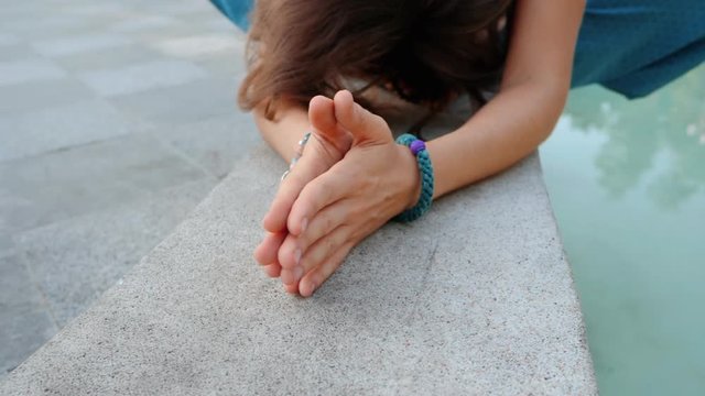 Woman bows with hands together from seated position