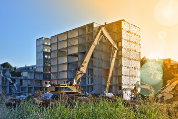 Demolished residential building being torn down by two excavators