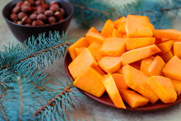 Sliced slices of pumpkin for a Christmas cake with spruce branches.