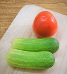 Fresh Tomato with Cucumbers on Cutting Board