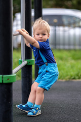 Toddler boy at playground wearing shorts and suspenders