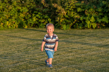 One year old baby boy running on meadow