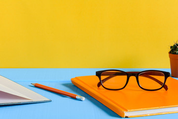 Books Pencil and glasses on a blue wooden table