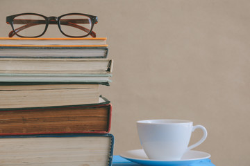 Book glasses and tea on the desk with study and education concept