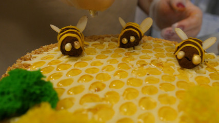 Close up hand pouring honey on the cake. Pouring honey on the cake