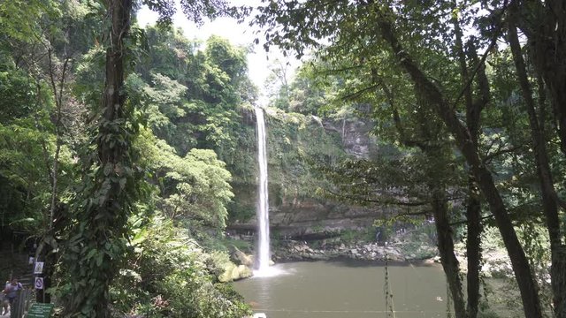 Huge tropical waterfall is falling dawn to river in the jungle at summer sunny day