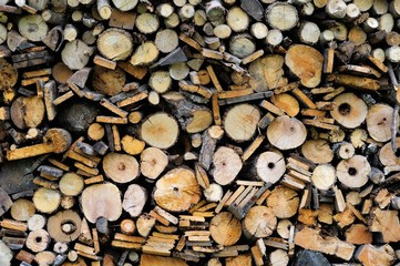 Preparation of firewood for the winter. A background of beautifully arranged pieces of wood with a variety of cuts.